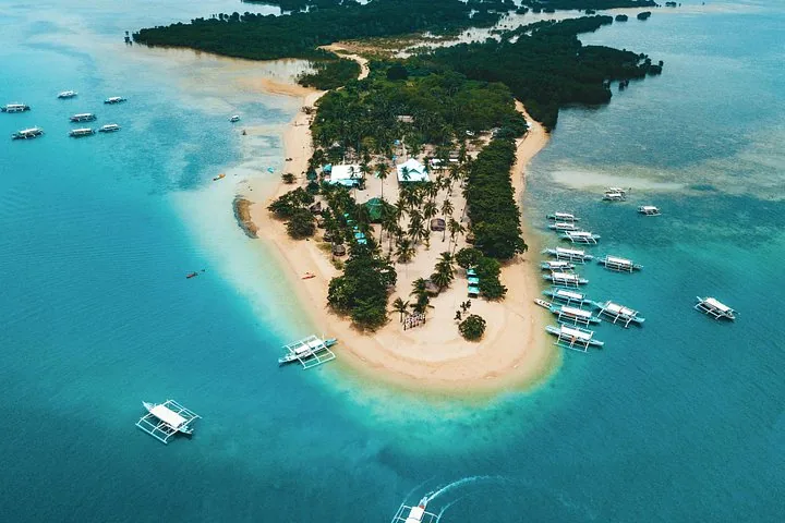Luftaufnahme einer tropischen Insel mit Booten, die am Strand angelegt haben.